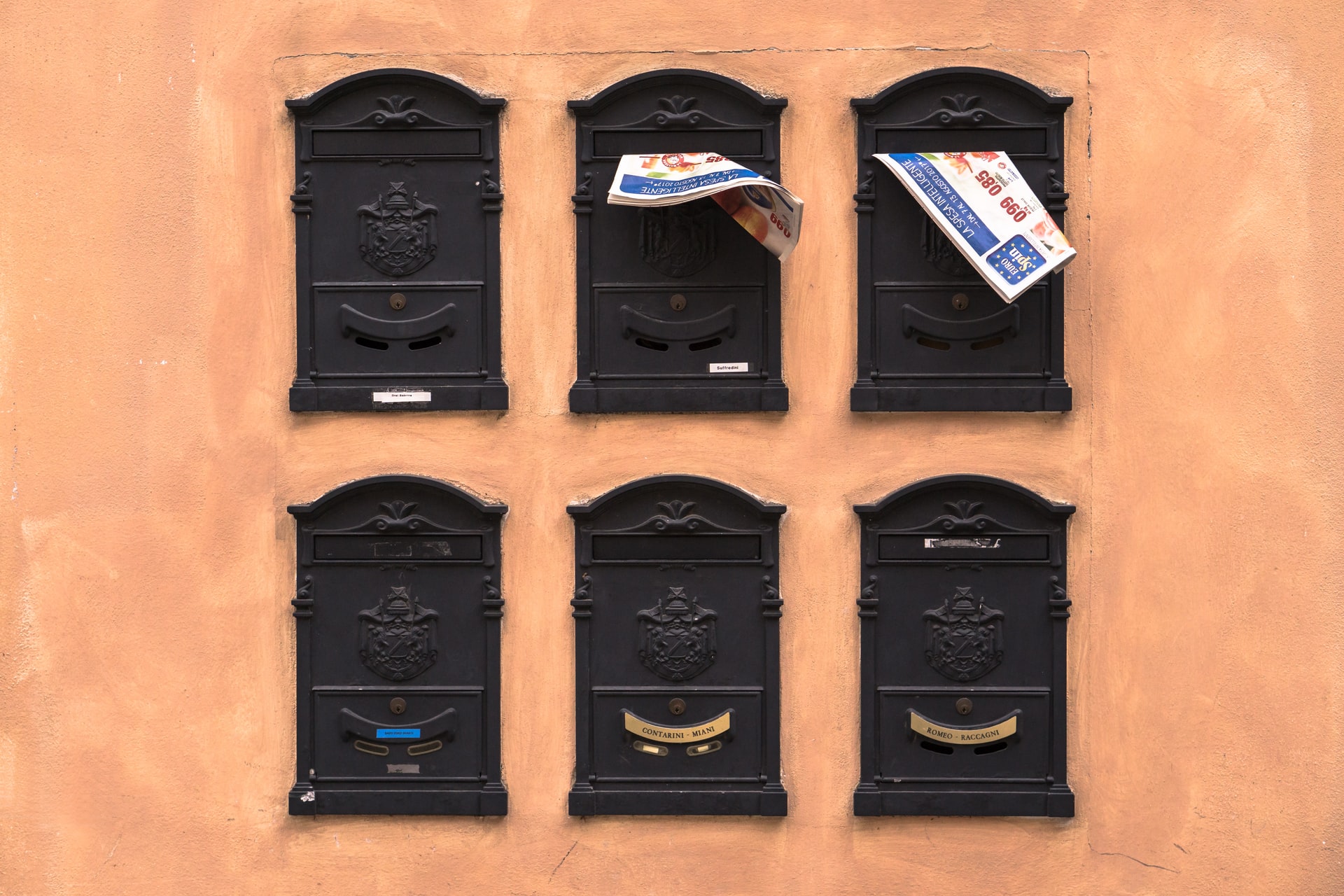 skrzynki pocztowe (czarne, 6 sztuk), w środku ulotki